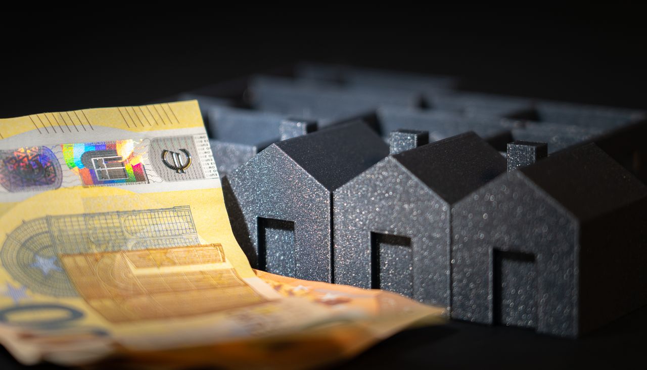 heros-img Close-up of black miniature houses with Euro notes, representing real estate investment and savings.